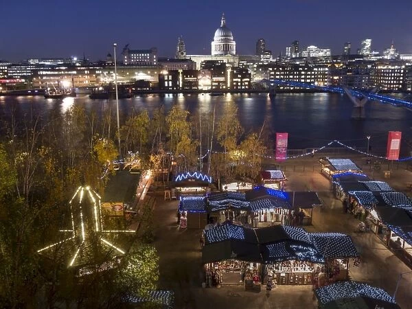 Christmas market with St. Pauls and Millennium Bridge, with City skyline dusk, London