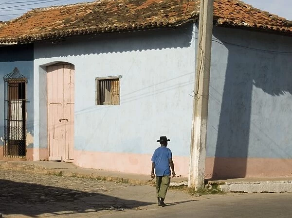 A man walking past colourfully painted houses in Trinidad, UNESCO World Heritage Site