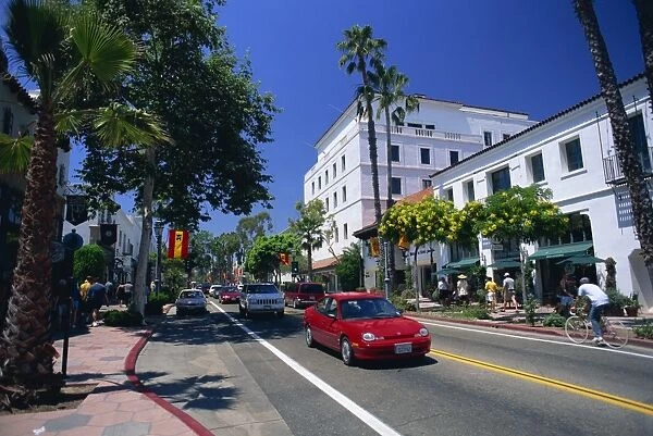 Red car and flowering trees on State Street in Santa Barbara