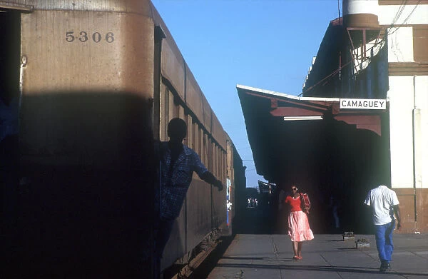 10011442. CUBA Camaguey Station platform with train standing and people walking