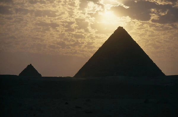 10053768. EGYPT Cairo Area Giza The Pyramids silhouetted at sunset.