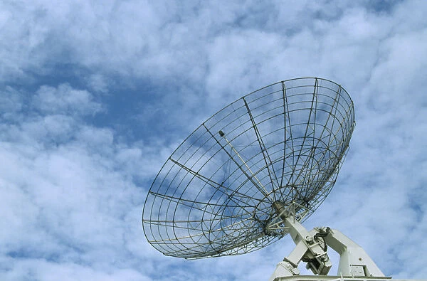 10070380. COMMUNICATIONS Satellite Dish Satellite dish with a light clouded sky behind