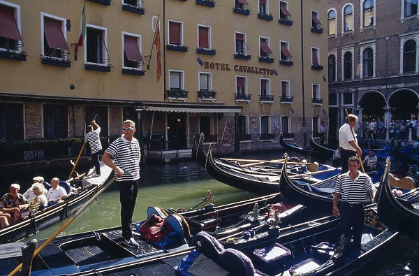 20015653. ITALY Veneto Venice Gondolas tied up at Hotel Cavalletto with gondolier