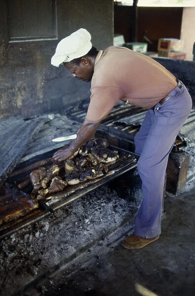 20030805. WEST INDIES Jamaica Food Man cooking jerk pork over an open fire