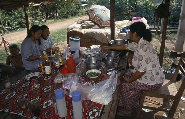 20031630. LAOS Vientiane Two girls eating at Mrs Tongs roadside noodle stall