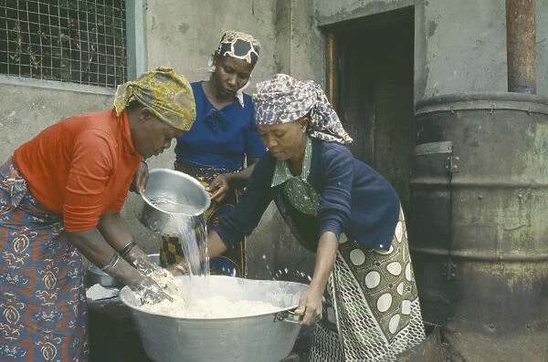 20039444. TANZANIA Arusha Women preparing dough to make bread