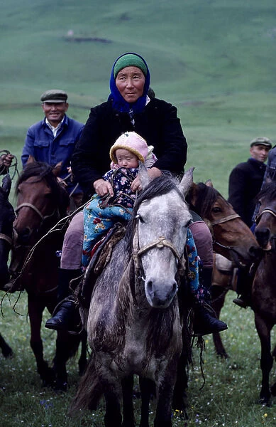 20050138. CHINA Xinjiang Province Kazakh mother and young child travelling on horseback