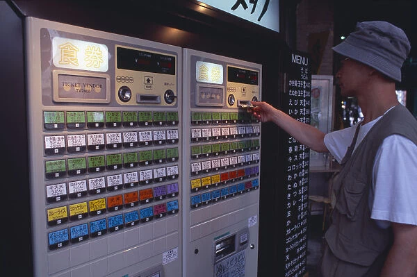 20060604. JAPAN Honshu Tokyo Shimbashi. Man using Restaurant Ticket vending machine