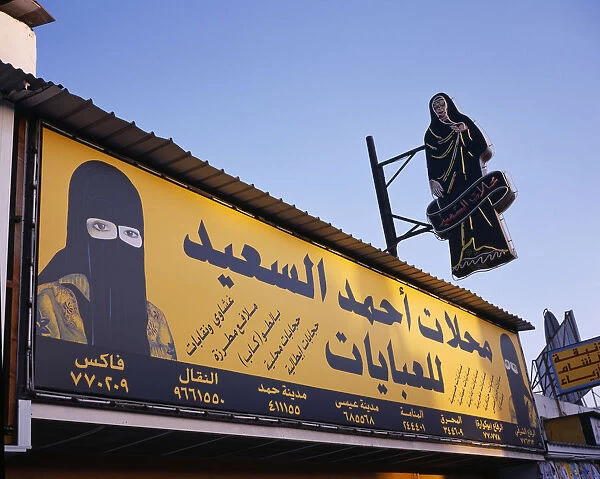 20081191. BAHRAIN Muharraq Island Markets Shopfront sign with images of a woman in a veil