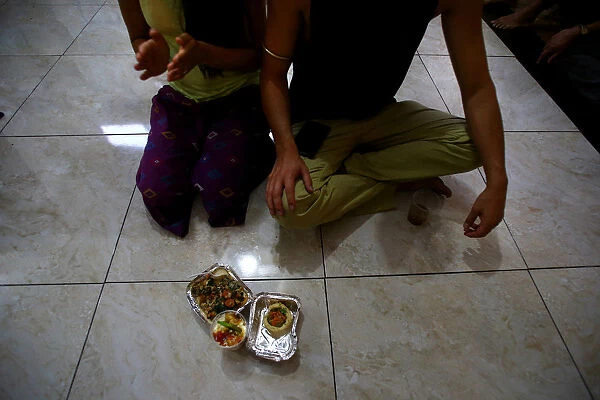 Hare Krishna devotees sit next to their vegetarian food at a temple in Santiago
