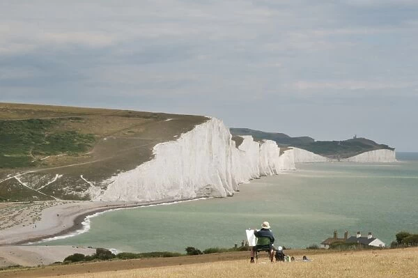 Artist with easel, painting chalk sea cliffs, Seven Sisters, Seaford, South Downs N. P. East Sussex, England, july