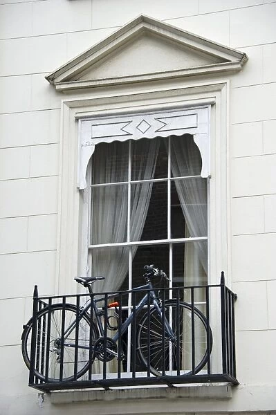 Bicycle on small balcony of city building, London, England, april