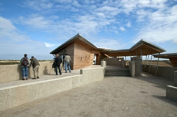 Birdwatchers standing beside new hides and information centre in coastal wetland reserve, Titchwell RSPB Reserve