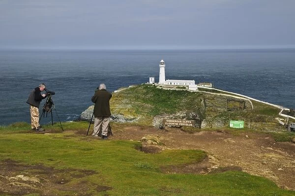 Birdwatchers using spotting scopes to view nesting seabirds on cliffs, beside Dangerous Cliffs