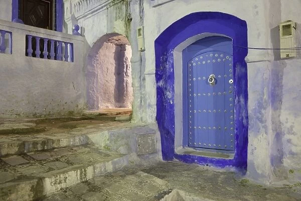 Blue door in alley of city at night, Chefchaouen, Morocco, april