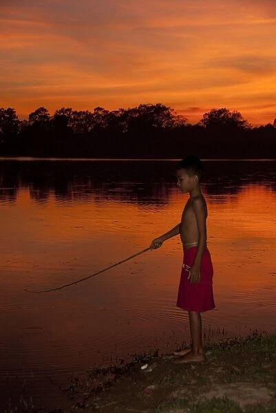 Boy fishing in lake at sunset, Pre Rup, Angkor, Siem Riep, Cambodia