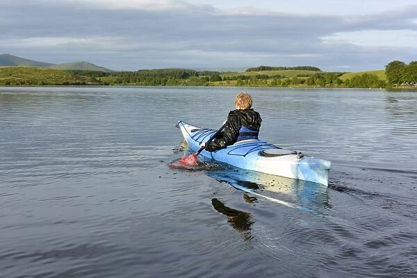 Boy kayaking on reservoir, Killington Lake, Killington Beck, Cumbria, England, June