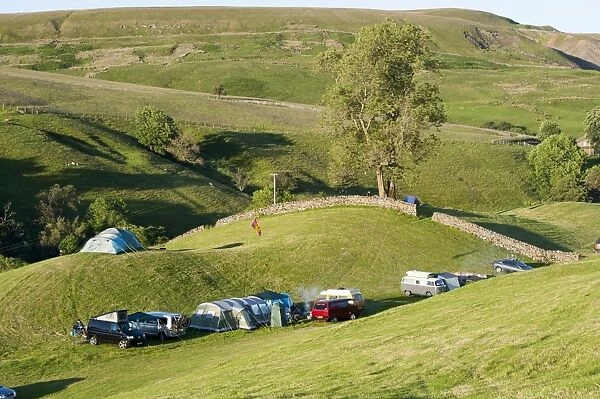 Campsite with campervans and tents on farmland in evening, Swaledale, Yorkshire Dales N. P