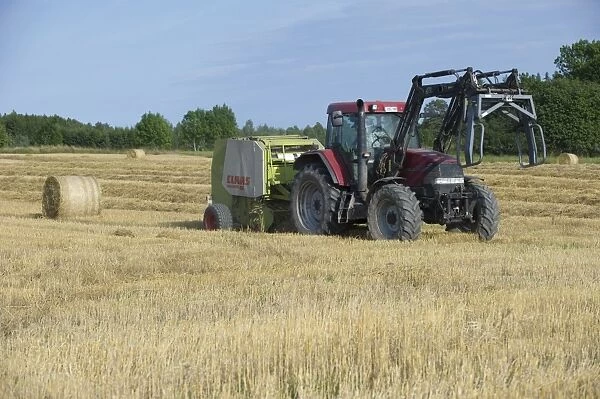 Case MX120 tractor with Trima loader and Cls round baler, baling straw in stubble field, Sweden, august