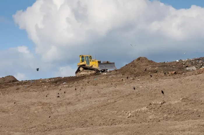 Framed Print : Caterpillar D6N compaction machine working on council rubbish tip, with scavenging crows, near Ellesmere, Cheshire