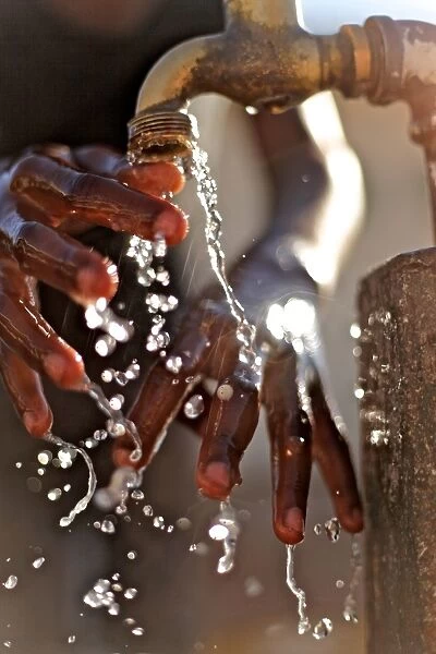 Close-up of hands under tap, Maun, Botswana, July