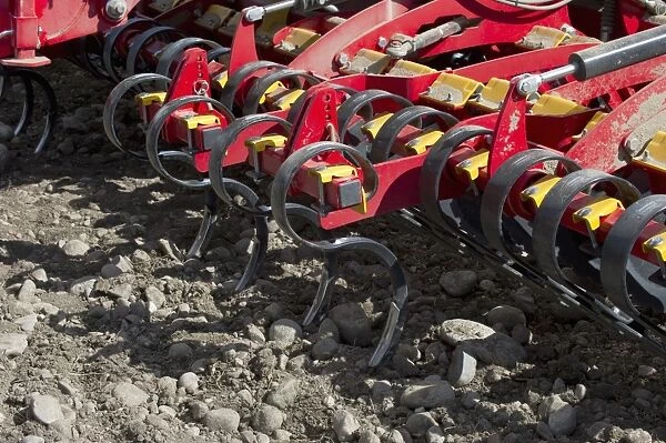 Close-up of Vaderstad Spirit 800S cultivator drill tines, in arable field with stony soil, Sweden, may