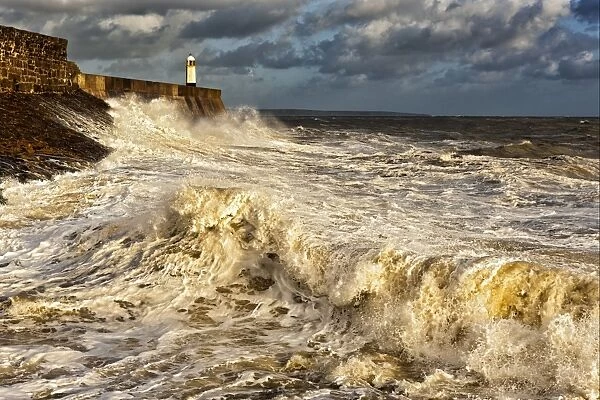 Coastal resort town seafront and lighthouse bombarded by waves, Porthcawl Pier, Porthcawl, Bristol Channel