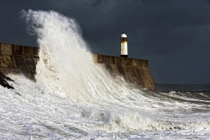 Framed Print : Coastal resort town seafront and lighthouse bombarded by waves during storm, Porthcawl Pier, Porthcawl