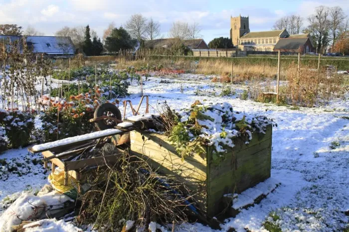 Framed Print : Compost heap in snow covered village allotments, with church in background, St Framed Print : Compost heap in snow covered village allotments, with church in background, St