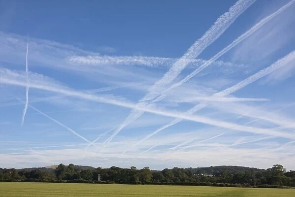 Condensation trails in sky, artificial clouds formed behind aircraft, Singleton, Chichester, West Sussex, England