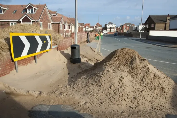 Framed Print : Council workers clearing away sand blown from beach and dunes onto road and pavement in seaside resort town, Lytham St. Anne's, Lancashire, England, january Framed Print : Council workers clearing away sand blown from beach and dunes onto road and pavement in seaside resort town, Lytham St. Anne's, Lancashire, England, january