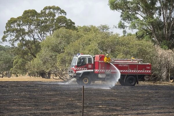 Country Fire Authority firemen putting out grass fire, Langley, Victoria, Australia, February