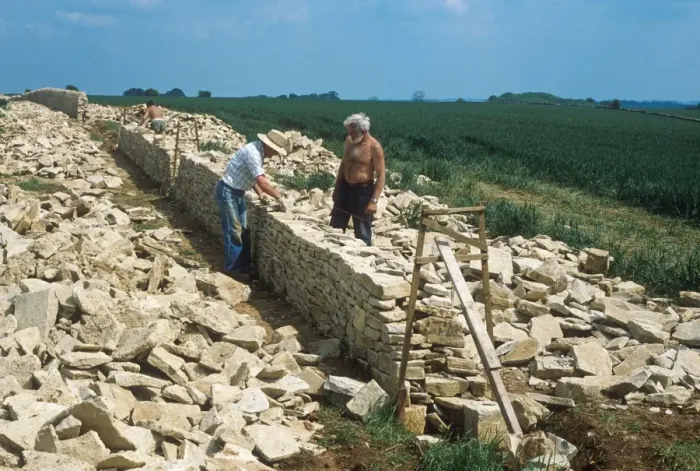 Framed Print : Drystone wall under construction, men using Cotswold stone, Gloucestershire, England Framed Print : Drystone wall under construction, men using Cotswold stone, Gloucestershire, England