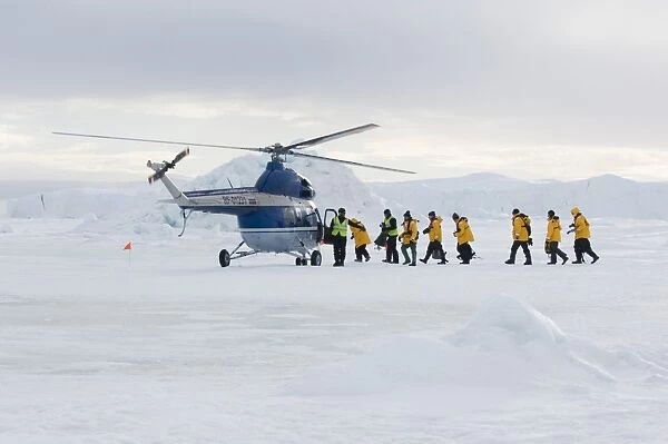 Eco-tourists boarding helicopter, to be taken back to Kapitan Klebnikov icebreaker from Emperor Penguin colony, Snow Hill Island, Weddell Sea, Antarctica, november