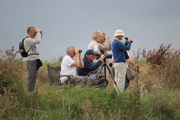 Elderly birdwatchers with binoculars and telescope, Titchwell RSPB Reserve, Norfolk, England, September