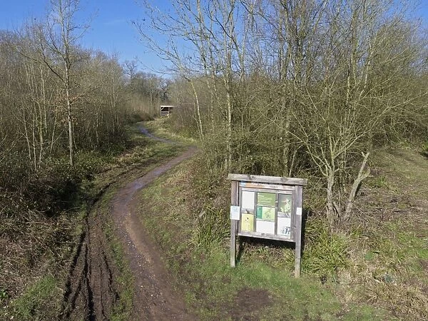 Entrance sign and track in woodland habitat, Highnam Woods RSPB Reserve, Gloucestershire, England, March