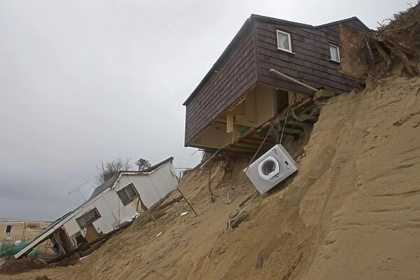 Eroded sea cliffs and damaged chalets after December 2013 tidal surge, Hemsby, Norfolk, England, January