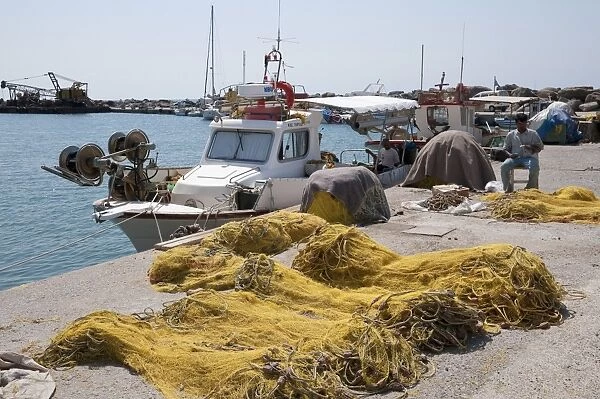 Fisherman repairing nets on harbour, Vlychada, Santorini, Cyclades, Aegean Sea, Greece, September
