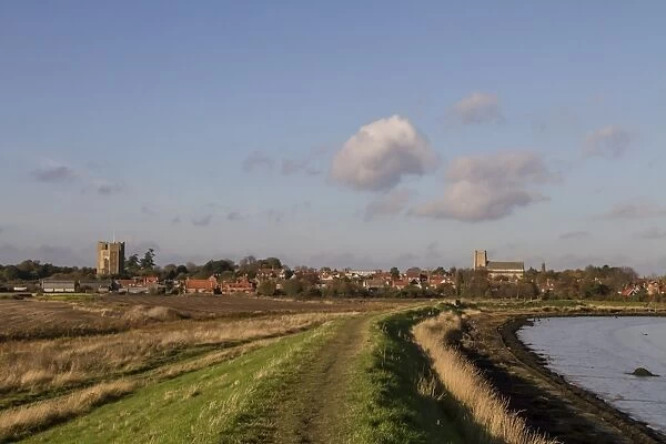 Footpath on the sea wall looking over the village of Orford with its Norman castle and church, Suffolk