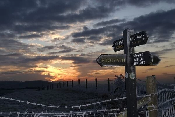 Frost covered footpath sign and fence at sunset, Ridgeway Path, near Aldbury, Chilterns, Hertfordshire, England