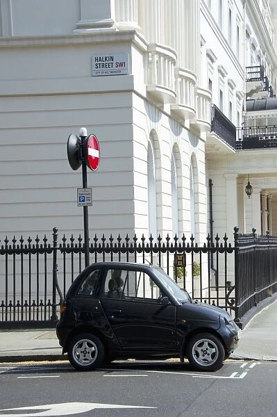 G-Wiz electric car parked on city street, Halkin Street, City of Westminster, London, England, april