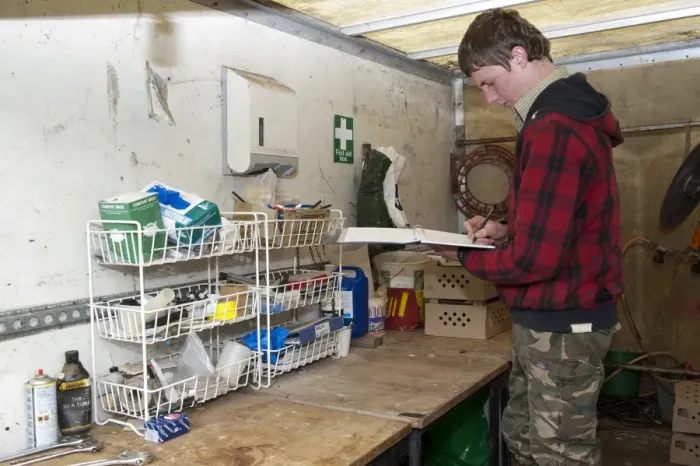 Framed Print : Gamebird farming, trainee gamekeeper filling in animal medicine book on shooting estate, England, May Framed Print : Gamebird farming, trainee gamekeeper filling in animal medicine book on shooting estate, England, May