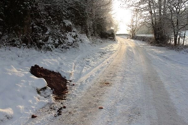 Grit and salt heap left on roadside by council in rural area during snowy conditions, North Wales, december