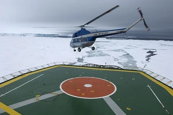 Helicopter with tourists, taking off from heli-deck on Kapitan Khlebnikov icebreaker, on route to view Snow Hill Island Emperor Penguin colony, Weddell Sea, Antarctica, november