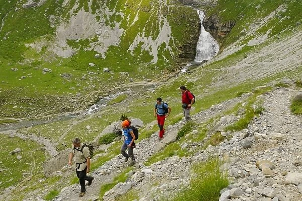 Hikers walking in mountain cirque near waterfall, Cola de Caballo Waterfall, Ordesa y Monte Perdido N. P
