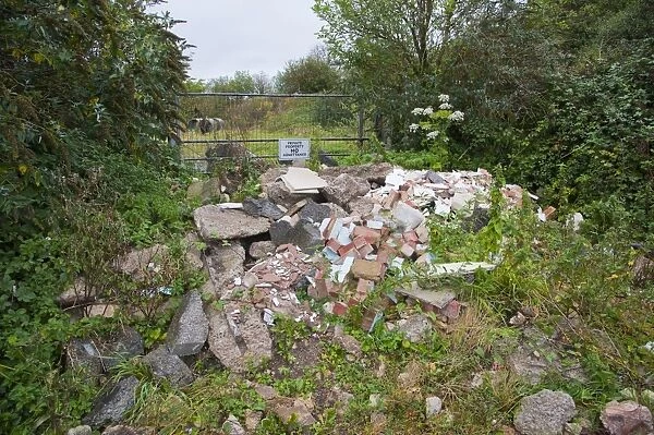 Illegal flytipping of building rubble in front of farm gateway with Private Property, No Admittance sign