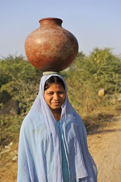 Indian girl carrying water container on head, near Bharatpur, Rajasthan, India, December