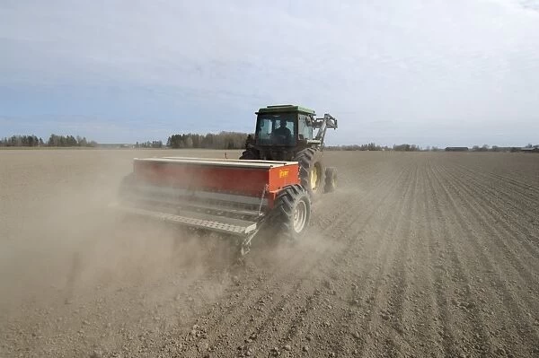 John Deere 2140 tractor with Tume seed drill, sowing arable crop in dusty field, Sweden, may