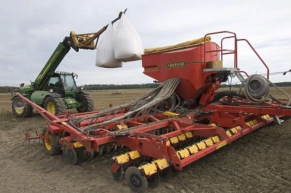 John Deere 3400 telehandler with bags of wheat seed, loading Vaderstad seed drill, Sweden, autumn