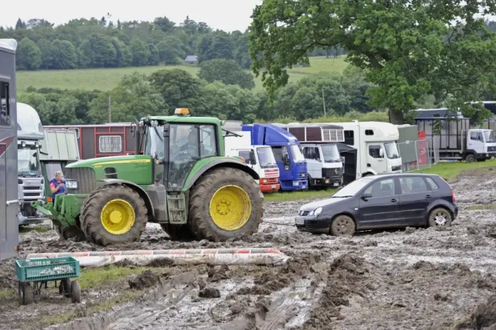 Framed Print : John Deere 6930 tractor pulling car out of muddy carpark at agricultural show, which was cancelled due to bad weather